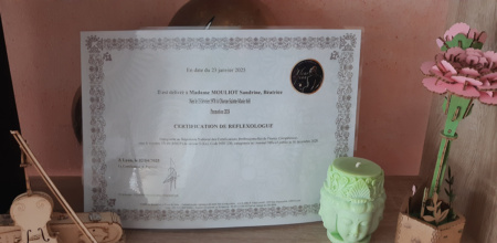 Certificat de réflexologie encadré sur étagère.